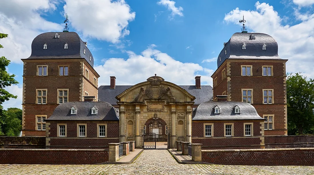Eingangsbereich von Schloss Ahaus mit Tor und zwei Türmen.